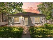 Charming single-story home featuring a well-kept lawn, grey paint and easy access to the front door via a sidewalk at 1177 Wabash St, Denver, CO 80220