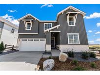 Attractive two-story home featuring gray siding, white brick accents, and an attached two-car garage at 3444 Recess Pt, Castle Rock, CO 80108
