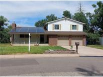 Brick ranch home with solar panels, two-car garage, and landscaped yard at 6618 S Newland Cir, Littleton, CO 80123