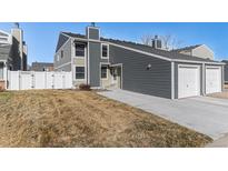 Charming townhome with gray siding, a well-manicured lawn, and an attached two-car garage at 11917 Monroe St, Thornton, CO 80233