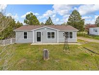 Charming single-story home featuring a well-maintained lawn and a decorative windmill at 762 S Paddock St, Elizabeth, CO 80107