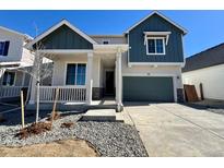 Inviting two-story home featuring a covered porch, an attached garage, and low-maintenance landscaping at 190 Lark Sparrow Way, Bennett, CO 80102