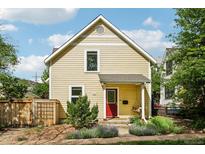 Charming home featuring a bright red front door, yellow siding, and well-maintained landscaping at 2255 18Th St, Boulder, CO 80302