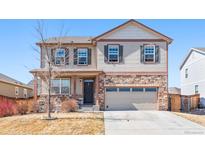 Charming two-story home featuring a brick facade, attached two-car garage, and landscaped front yard at 13673 Valentia St, Thornton, CO 80602