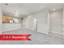 Spacious living room featuring neutral walls, plush carpet, and an open floor plan to the kitchen and staircase at 1401 W 85Th Ave # F201, Federal Heights, CO 80260