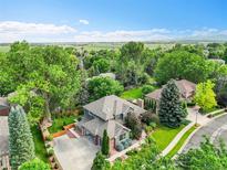 Stunning aerial view of a beautiful home with lush landscaping, mature trees, and a well-manicured lawn at 1321 Ruby Way, Longmont, CO 80504