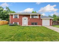 Charming red brick home with well-maintained lawn and attached one car garage at 6721 Quay Ct, Arvada, CO 80003