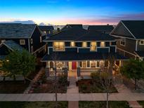 Stunning two-story home showcasing a charming front porch and manicured landscaping, perfect for outdoor relaxation at 9446 E 51St Dr, Denver, CO 80238