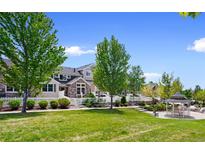 Charming townhouse with a white picket fence, lush lawn, mature trees, and a gazebo in the common area at 14247 Pikeminnow Pl, Broomfield, CO 80023