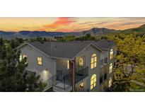 Charming multi-level home with mountain views, balconies, and arched windows at sunset at 1670 S Deframe St # C2, Lakewood, CO 80228