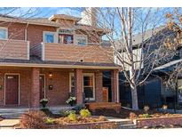 Inviting brick home featuring a cozy front porch and manicured landscaping at 4511 Perry St, Denver, CO 80212