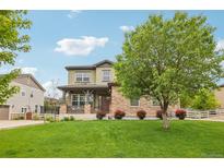 Charming two-story home with a lush green lawn, stone accents, and a welcoming front porch at 2605 Gray Wolf Loop, Broomfield, CO 80023