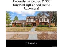 Charming two-story home with brick and Tudor accents, plus a well-manicured lawn at 2011 S Gray Dr, Lakewood, CO 80227
