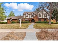 Charming two-story Tudor-style home with brick facade and manicured landscaping at 2011 S Gray Dr, Lakewood, CO 80227