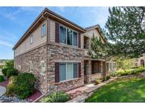 Charming two-story townhouse featuring a stone facade, red shutters, and well-maintained landscaping at 22920 E Roxbury Dr # H, Aurora, CO 80016