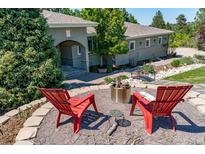 Inviting outdoor fire pit area with red Adirondack chairs and beautiful landscaping at 5631 Silver Bluff Ct, Parker, CO 80134