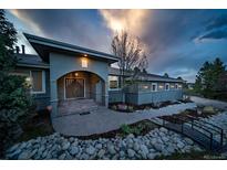 Inviting front exterior features a charming entryway, landscaped yard with a small bridge, and beautiful stone accents at 5631 Silver Bluff Ct, Parker, CO 80134