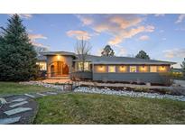 Stunning home exterior with bridge to front door and beautifully landscaped front yard at 5631 Silver Bluff Ct, Parker, CO 80134