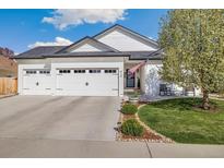 Charming single-story home featuring a three-car garage, manicured lawn, and American flag at 410 Clover Ct, Frederick, CO 80530