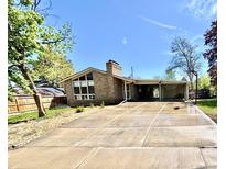 Charming brick home featuring a large driveway, mature trees, and well-maintained landscaping at 414 S Nelson S St, Lakewood, CO 80226