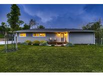 Inviting front yard with fresh green grass and cozy porch chairs and well-maintained landscaping at 1100 E Harvey St, Castle Rock, CO 80108