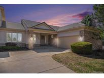 Charming stucco home featuring a tiled roof, stone accents, covered entryway, and attached garage at 13806 E Chenango Dr, Aurora, CO 80015