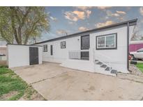 Charming home with black and white trim, featuring a cozy front porch and adjacent storage shed at 14701 E Colfax Ave # A5, Aurora, CO 80011
