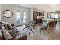 A cozy living room featuring modern furniture, a decorative rug, and french doors leading to an outdoor balcony at 4184 Kalamath St, Denver, CO 80211