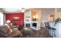 Inviting living room with fireplace, wood floors, and comfortable seating arrangement at 12606 S Sopris Creek Dr, Parker, CO 80134