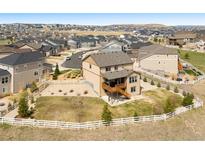 Areal view of two-story home featuring a spacious backyard with white picket fence in a Gathering-friendly neighborhood at 5998 Berry Ridge Way, Castle Rock, CO 80104