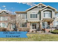 Charming townhome featuring a combination of stone and siding, coupled with a well-maintained lawn and patio, offering great curb appeal at 15064 E Crestridge Dr, Centennial, CO 80015