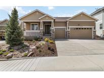 Charming home featuring a two-car garage, landscaped yard, and inviting front porch at 2724 Rising Moon Way, Castle Rock, CO 80109