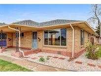 Charming single-story brick home featuring a well-maintained front yard and a cozy, covered entry, full of character at 3690 N Hudson St, Denver, CO 80207