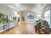 Bright living room featuring hardwood floors, large window and comfortable furnishings at 3690 N Hudson St, Denver, CO 80207