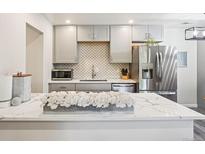 Modern kitchen featuring stainless steel appliances, white cabinets, and white countertops at 7995 E Mississippi Ave # F23, Denver, CO 80247