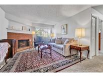 Cozy living room with a brick fireplace, comfortable seating and a large rug at 14226 E 1St Dr # B10, Aurora, CO 80011