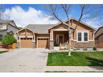 Charming single-Gathering home featuring a manicured lawn, stone accents, and an attached two-car garage at 4553 Red Deer Trl, Broomfield, CO 80020