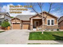 Inviting single-Gathering home showcasing two garage doors, stone accents, a well-manicured lawn, and seller concessions! at 4553 Red Deer Trl, Broomfield, CO 80020