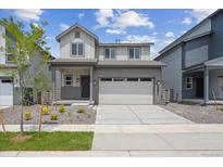 Charming two-story home with a two-car garage, a landscaped front yard, and a welcoming entrance at 19059 E 94Th Pl, Commerce City, CO 80022
