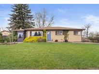 Charming brick home with a well-manicured lawn and landscaping in a peaceful neighborhood setting at 865 S Everett St, Lakewood, CO 80226