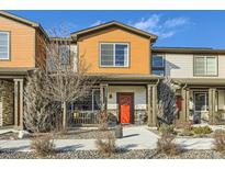 Charming townhome featuring a welcoming red door, covered porch and low maintenance landscaping at 21613 E 59Th Pl, Aurora, CO 80019