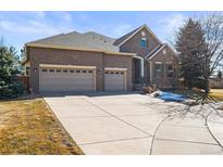 Charming brick home with a three-car garage and large driveway at 26426 E Peakview Dr, Aurora, CO 80016