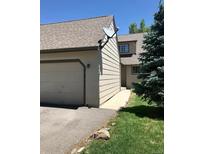 Exterior view featuring an attached garage and well-maintained lawn, with sidewalk leading to entry at 10369 E Red Mtn, Littleton, CO 80127