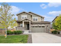 Charming two-story home with stone accents, manicured lawn, and welcoming front porch at 26267 E 3Rd Ave, Aurora, CO 80018