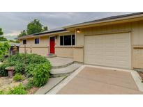Charming single-story home featuring a red front door and an attached one car garage at 9743 W 67Th Pl, Arvada, CO 80004