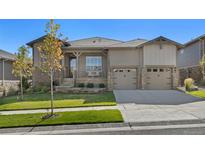 Charming home with covered porch, stone accents, two-car garage, and well-maintained landscaping at 21972 E Allenspark Dr, Aurora, CO 80016