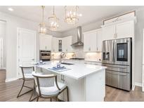 Bright, modern kitchen with stainless steel appliances, quartz countertops, and decorative pendant lighting at 21972 E Allenspark Dr, Aurora, CO 80016