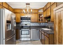 Updated kitchen with stainless steel appliances, stylish backsplash, and sleek countertops at 615 S Alton Way # 7A, Denver, CO 80247