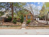 Charming log cabin-style home with a cozy front porch and well-maintained landscaping at 8409 S Otis St, Littleton, CO 80128