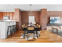 Charming dining room with brick accent wall, chandelier, and seating for six at 425 S Reed St, Lakewood, CO 80226